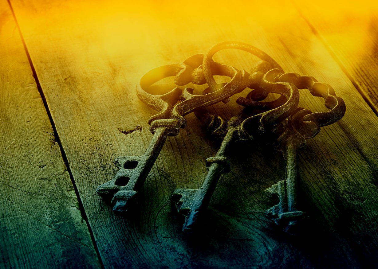 Three antique keys on wooden surface.